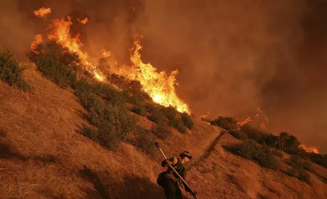 A firefighter battles the Palisades Fire in Mandeville Canyon Saturday, Jan. 11, 2025, in Los Angeles. (AP Photo/Jae C. Hong)