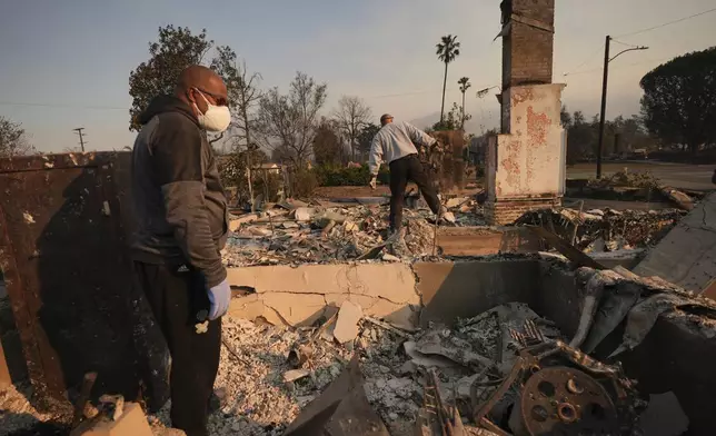 Kenneth Snowden, left, surveys the damage to his fire-ravaged property with his brother Ronnie in the aftermath of the Eaton Fire Friday, Jan. 10, 2025 in Altadena, Calif. (AP Photo/Jae C. Hong)