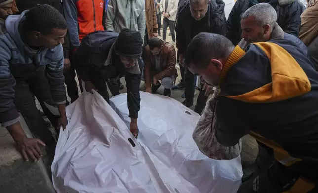 Mourners attend the funeral of three members of Imad Al-deen family who were killed in the Israeli bombardment in Bureij, central Gaza Strip, at Al-Aqsa Martyrs Hospital in Deir al-Balah, Monday, Jan. 6, 2025. (AP Photo/Abdel Kareem Hana)