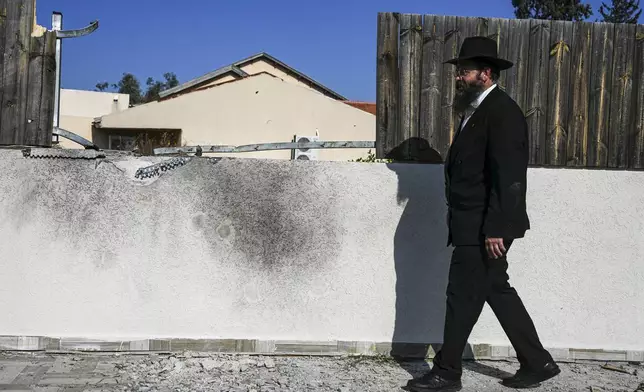 A man surveys a damaged home after a rocket fired by Palestinian militants from Gaza Strip hit in the town of Sderot, southern Israel Monday, Jan. 6, 2025. (AP Photo/Tsafrir Abayov)