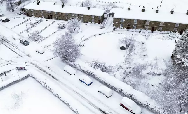 A view of a blanket of snow on cars and houses, in Allenheads, in the Pennines, Northumberland, England, Monday, Jan. 6, 2025. (Owen Humphreys/PA via AP)