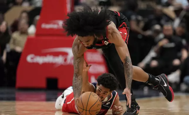 Chicago Bulls guard Coby White (0) recovers the ball ahead of Washington Wizards guard Jordan Poole (13) during the first half of an NBA basketball game, Wednesday, Jan. 1, 2025, in Washington. (AP Photo/Jess Rapfogel)