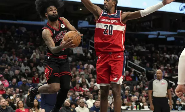 Chicago Bulls guard Coby White (0) goes up against Washington Wizards forward Alex Sarr (20) during the first half of an NBA basketball game, Wednesday, Jan. 1, 2025, in Washington. (AP Photo/Jess Rapfogel)