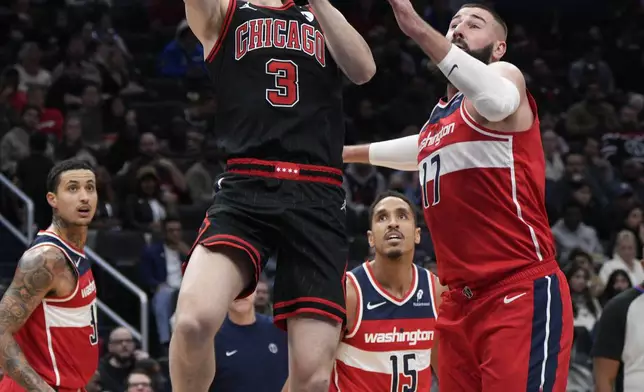 Chicago Bulls guard Josh Giddey (3) shoots against Washington Wizards center Jonas Valanciunas (17) during the first half of an NBA basketball game, Wednesday, Jan. 1, 2025, in Washington. (AP Photo/Jess Rapfogel)