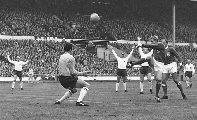 FILE - England goalkeeper Gordon Banks, left, positions himself as Scottish inside-right Denis Law takes a shot at goal during the first half of the Football Association Centenary soccer match between England and the "Rest of the World team" at Wembley Stadium in London on Oct. 23, 1963. (AP Photo/Bippa, File)