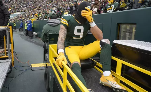 Green Bay Packers wide receiver Christian Watson (9) is carted off the field during the first half of an NFL football game against the Chicago Bears, Sunday, Jan. 5, 2025, in Green Bay, Wis. (AP Photo/Morry Gash)