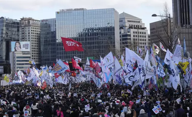 Protesters carry flags during a rally demanding immediate indictment of impeached South Korean President Yoon Suk Yeol in Seoul, South Korea, Saturday, Jan. 25, 2025. (AP Photo/Ahn Young-joon)