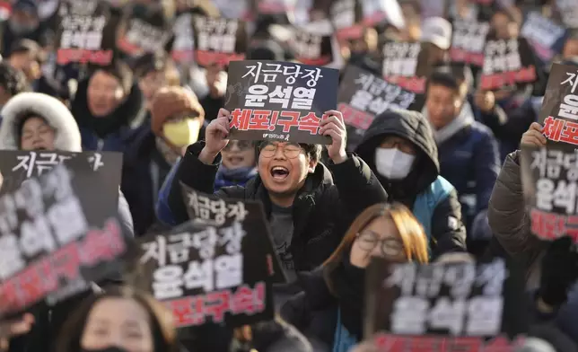 Members of the Korean Confederation of Trade Unions shout slogans during a rally demanding the arrest of impeached President Yoon Suk Yeol near the presidential residence in Seoul, South Korea, Friday, Jan. 3, 2025. The letters read "Immediately arrest Yoon Suk Yeol." (AP Photo/Lee Jin-man)