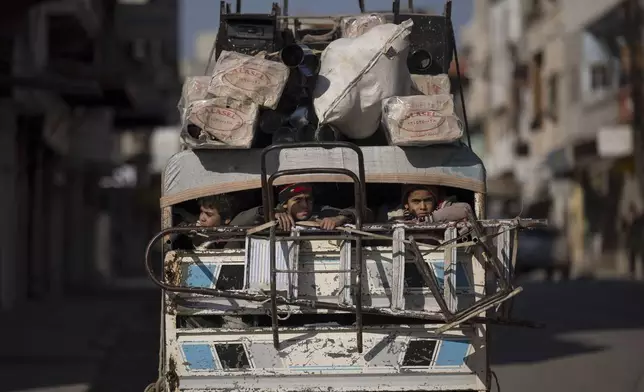 Boys ride on the back of a truck in Homs, Syria, Friday, Jan. 3, 2025. (AP Photo/Leo Correa)