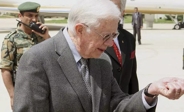 FILE - Former U.S. President Jimmy Carter looks at his watch upon arriving at Queen Alia International airport in Amman ,Jordan, on April 20, 2008. Earlier on his Middle East tour, Carter met with exiled Hamas leader Khaled Meshaal despite strong opposition from Israel and the White House. (AP Photo/Jamal Nasrallah, Pool, File)