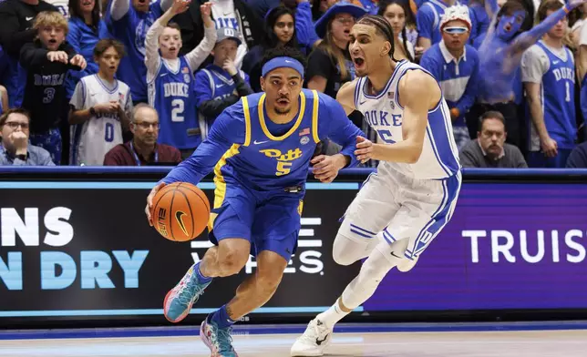 Pittsburgh's Ishmael Leggett, left, drives against Duke's Tyrese Proctor during the first half of an NCAA college basketball game in Durham, N.C., Tuesday, Jan. 7, 2025. (AP Photo/Ben McKeown)