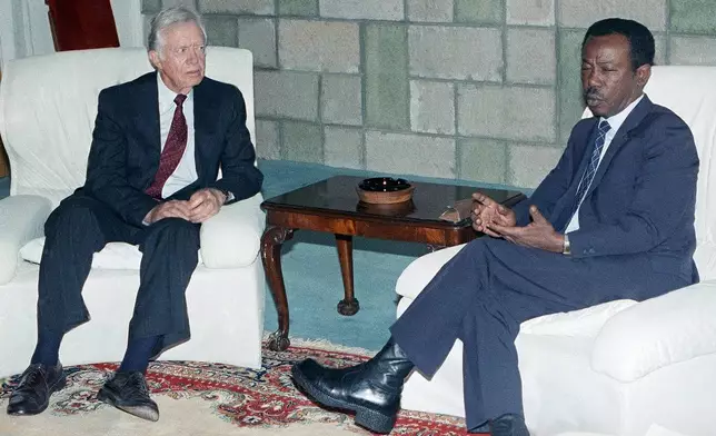 FILE - Former U.S. President Jimmy Carter, left, speaks with Ethiopian President Mengistu Haile Mariam in Addis Ababa, July 11, 1990, during the 26th summit of the Organization of African Unity. (AP Photo/Aris Saris, File)