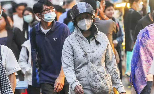 A woman wears sweater in Bangkok, Thailand, Thursday, Jan. 16, 2025. (AP Photo/Sakchai Lalit)