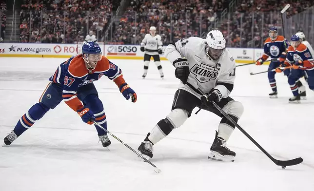 Los Angeles Kings' Anze Kopitar (11) is pursued by Edmonton Oilers' Connor McDavid (97) during first-period NHL hockey game action in Edmonton, Alberta, Monday, Jan. 13, 2025. (Jason Franson/The Canadian Press via AP)