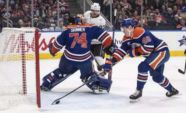 Los Angeles Kings' Kevin Fiala (22) gets the puck past Edmonton Oilers goalie Stuart Skinner (74) as Oilers' Ty Emberson (49) picks it up before it goes into the net during first-period NHL hockey game action in Edmonton, Alberta, Monday, Jan. 13, 2025. (Jason Franson/The Canadian Press via AP)