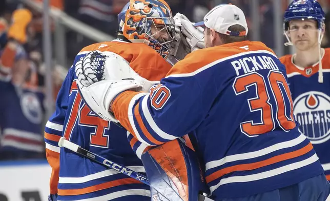 Edmonton Oilers goalie Stuart Skinner (74) and teammate Calvin Pickard (30) celebrate the win over the Los Angeles Kings in an NHL hockey game in Edmonton, Alberta, Monday, Jan. 13, 2025. (Jason Franson/The Canadian Press via AP)