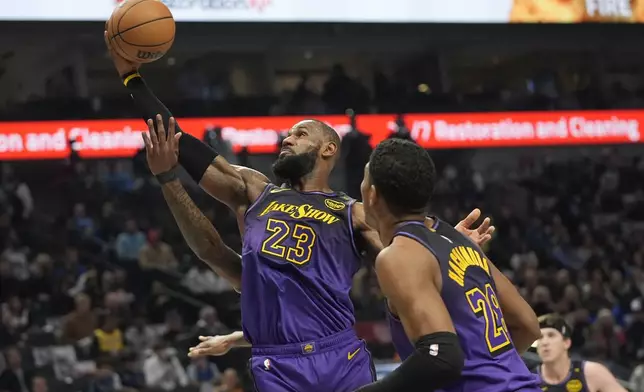 Los Angeles Lakers forward LeBron James (23) grabs a rebound in front of teammate forward Rui Hachimura during the first half of an NBA basketball game against the Dallas Mavericks Tuesday, Jan. 7, 2025, in Dallas. (AP Photo/LM Otero)