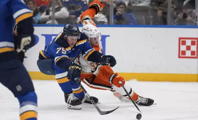 St. Louis Blues' Tyler Tucker (75) and Anaheim Ducks' Leo Carlsson battle for a loose puck during the third period of an NHL hockey game Thursday, Jan. 9, 2025, in St. Louis. (AP Photo/Jeff Roberson)