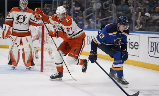 Anaheim Ducks' Leo Carlsson (91) battles for a loose puck with St. Louis Blues' Alexey Toropchenko (13) during the second period of an NHL hockey game Thursday, Jan. 9, 2025, in St. Louis. (AP Photo/Jeff Roberson)