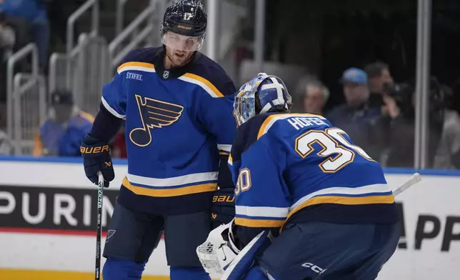 St. Louis Blues' Cam Fowler (17) talks with goaltender Joel Hofer (30) during the first period of an NHL hockey game against the Anaheim Ducks Thursday, Jan. 9, 2025, in St. Louis. (AP Photo/Jeff Roberson)