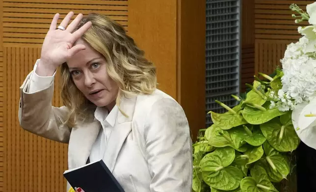 Italian Premier Giorgia Meloni waves at the end of the 2024 year-end press conference, in Rome, Thursday, Jan. 9, 2025. (AP Photo/Alessandra Tarantino)