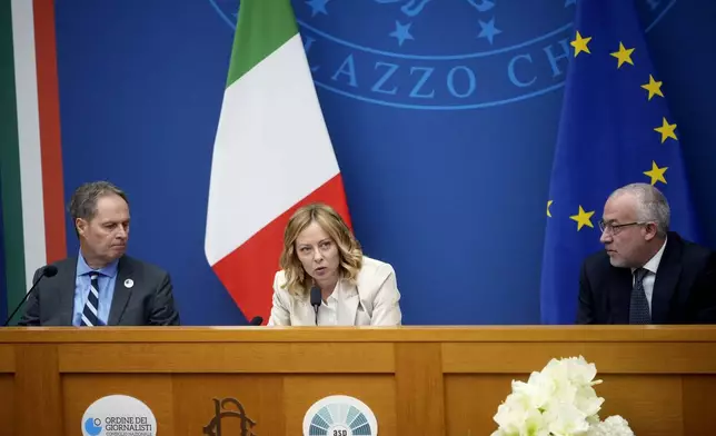 Italian Premier Giorgia Meloni holds the 2024 year-end press conference, flanked by the Italian president of the Order of Journalists, Carlo Bartoli, left, and Italian national press federation president Vittorio Di Trapani, in Rome, Thursday, Jan. 9, 2025. (AP Photo/Alessandra Tarantino)