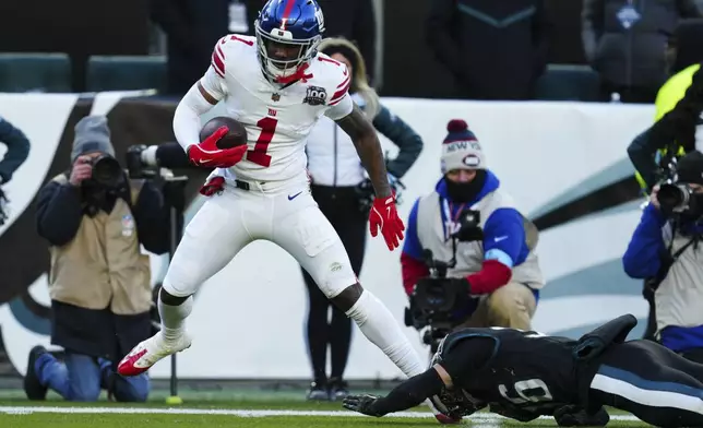 New York Giants wide receiver Malik Nabers (1) catches the ball before scoring a touchdown past Philadelphia Eagles safety Tristin McCollum (36) during the second half of an NFL football game Sunday, Jan. 5, 2025, in Philadelphia. (AP Photo/Derik Hamilton)