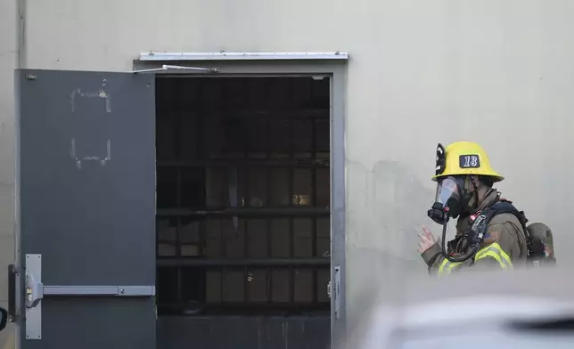 A firefighter enters a building where a plane crash occurred Thursday, Jan. 2, 2025, in Fullerton, Calif. (AP Photo/Kyusung Gong)