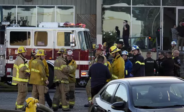 Firefighters respond to a commercial building where a small plane crashed on Thursday, Jan. 2, 2025, in Fullerton, Calif. (AP Photo/Damian Dovarganes)