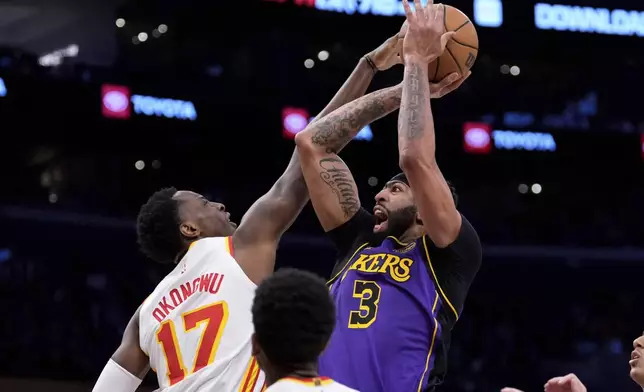 Los Angeles Lakers forward Anthony Davis, right, shoots as Atlanta Hawks forward Onyeka Okongwu defends during the first half of an NBA basketball game, Friday, Jan. 3, 2025, in Los Angeles. (AP Photo/Mark J. Terrill)