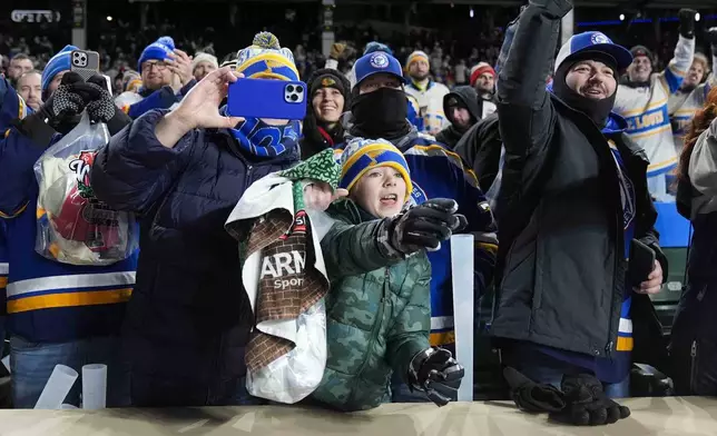 St. Louis Blues fans celebrate after the team's win over the Chicago Blackhawks in the NHL Winter Classic outdoor hockey game at Wrigley Field, Tuesday, Dec. 31, 2024, in Chicago. (AP Photo/Erin Hooley)