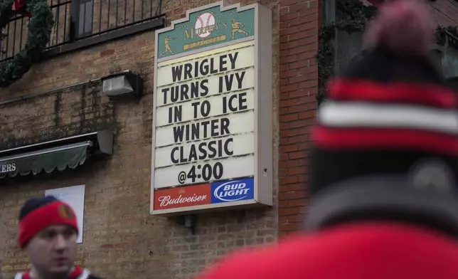 Fans hang outside of Murphy's Bleachers before the NHL Winter Classic outdoor hockey game between the Chicago Blackhawks and St. Louis Blues at Wrigley Field, Tuesday, Dec. 31, 2024, in Chicago. (AP Photo/Erin Hooley)