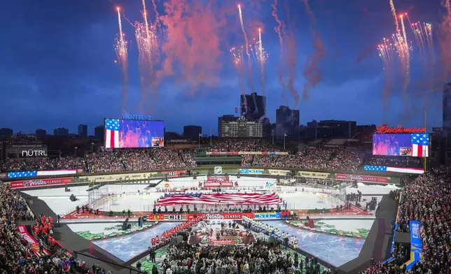 Fireworks explode during the Star-Spangled Banner before the NHL Winter Classic outdoor hockey game featuring the Chicago Blackhawks and St. Louis Blues at Wrigley Field, Tuesday, Dec. 31, 2024, in Chicago. (AP Photo/Erin Hooley)