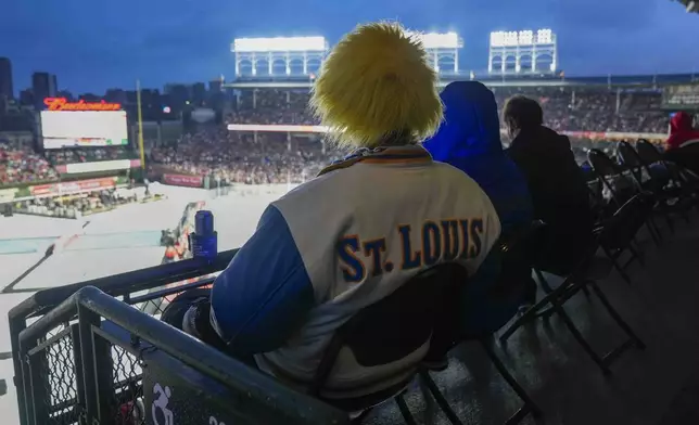 A St. Louis Blues fan watches the NHL Winter Classic outdoor hockey game between the Chicago Blackhawks and the Blues at Wrigley Field, Tuesday, Dec. 31, 2024, in Chicago. (AP Photo/Erin Hooley)