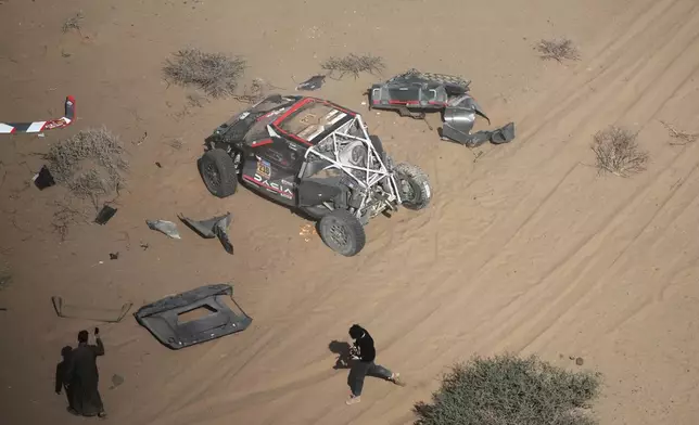 The car of Driver Sebastien Loeb and co-driver Fabian Lurquin is stopped after a crash during the third stage of the Dakar Rally between Bisha and Al-Henakiyah, Saudi Arabia, Tuesday, Jan. 7, 2025. (AP Photo/Christophe Ena)