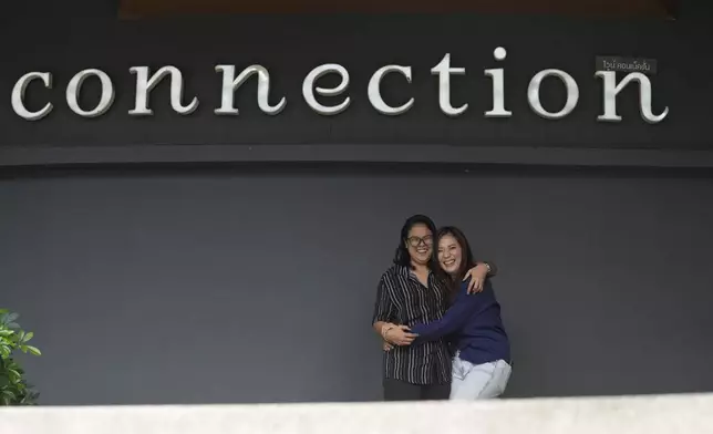 Patherine Khunnares, 37, web designer, left, and Vivian Chullamon, 36, researcher, stand for a photograph in Bangkok, Thailand, Sunday, Jan. 12, 2025. (AP Photo/Sakchai Lalit)