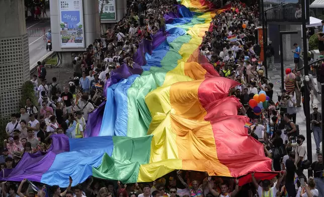 FILE - Participants hold a rainbow flag during the Pride Parade in Bangkok, Thailand, June 1, 2024. (AP Photo/Sakchai Lalit, File)