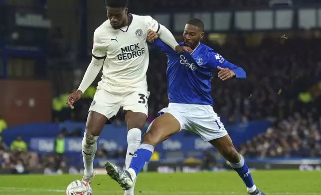 Peterborough United's Emmanuel Fernandez, left, and Everton's Beto battle for the ball during the English FA Cup third round soccer match between Everton and Peterborough United at Goodison Park, Liverpool, England, Thursday Jan. 9, 2025. (Peter Byrne/PA via AP)