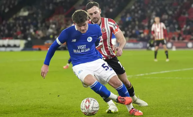 Cardiff City's Luke Pearce, left, and Sheffield United's Jack Robinson battle for the ball during the English FA Cup third round soccer match between Sheffield United and Cardiff City at Bramall Lane, Sheffield, England, Thursday Jan. 9, 2025. (Danny Lawson/PA via AP)