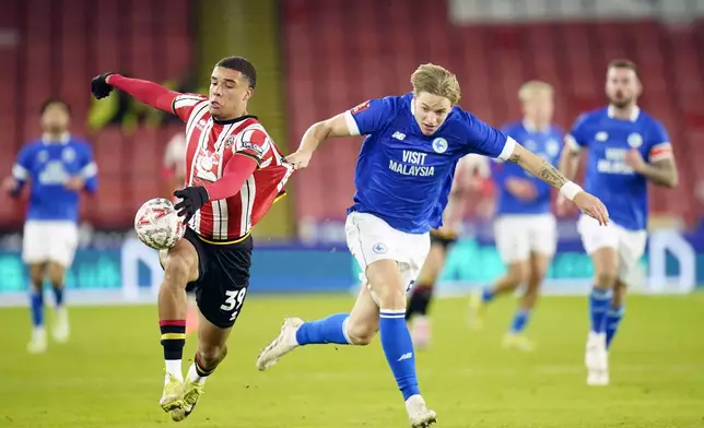 Sheffield United's Ryan One, left, and Cardiff City's Jesper Daland battle for the ball during the English FA Cup third round soccer match between Sheffield United and Cardiff City at Bramall Lane, Sheffield, England, Thursday Jan. 9, 2025. (Danny Lawson/PA via AP)