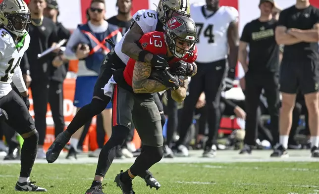 Tampa Bay Buccaneers wide receiver Mike Evans (13) pulls in a pass against New Orleans Saints cornerback Will Harris (5) during the first half of an NFL football game Sunday, Jan. 5, 2025, in Tampa, Fla. (AP Photo/Jason Behnken)