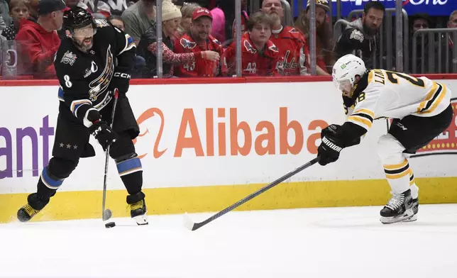 Washington Capitals left wing Alex Ovechkin (8) passes the puck against Boston Bruins center Elias Lindholm (28) during the first period of an NHL hockey game, Tuesday, Dec. 31, 2024, in Washington. (AP Photo/Nick Wass)