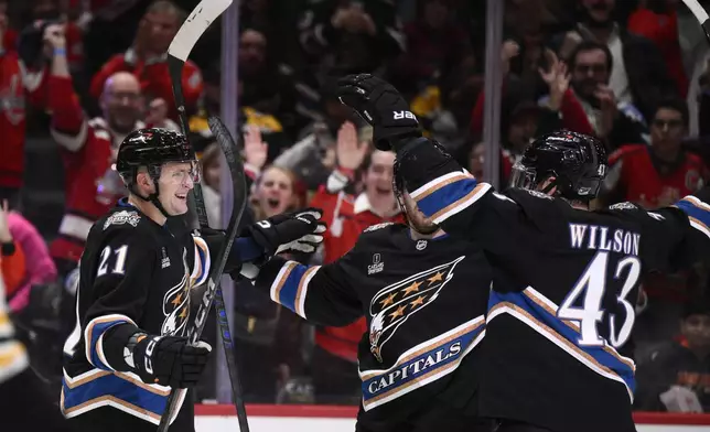 Washington Capitals center Aliaksei Protas (21) celebrates his goal with right wing Tom Wilson (43) during the first period of an NHL hockey game against the Boston Bruins, Tuesday, Dec. 31, 2024, in Washington. (AP Photo/Nick Wass)