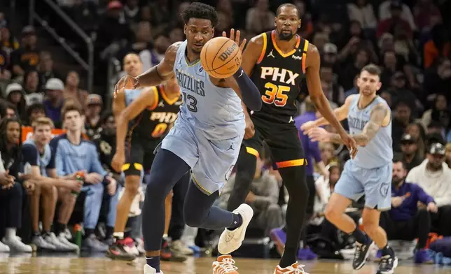 Memphis Grizzlies forward Jaren Jackson Jr. (13) gets to the ball in front of Phoenix Suns forward Kevin Durant (35) during the first half of an NBA basketball game Tuesday, Dec. 31, 2024, in Phoenix. (AP Photo/Darryl Webb)