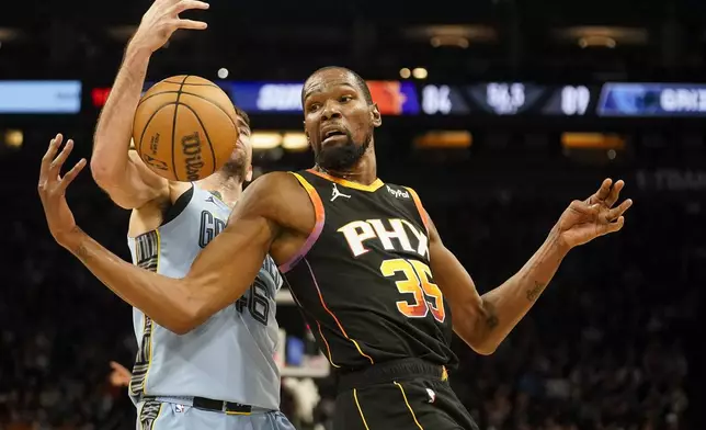 Phoenix Suns forward Kevin Durant (35) loses the ball as Memphis Grizzlies guard John Konchar, left, reaches in during the second half of an NBA basketball game Tuesday, Dec. 31, 2024, in Phoenix. (AP Photo/Darryl Webb)