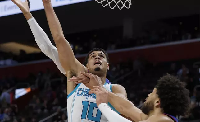 Charlotte Hornets guard Josh Green (10) takes a shot against Detroit Pistons guard Cade Cunningham, right, during the first half of an NBA basketball game Friday, Jan. 3, 2025, in Detroit. (AP Photo/Duane Burleson)