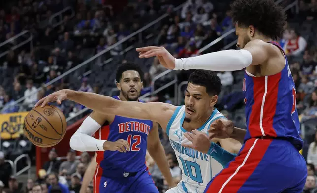 Charlotte Hornets guard Josh Green (10) tries going to the basket against Detroit Pistons guard Cade Cunningham, right, with forward Tobias Harris (12) watching the play during the first half of an NBA basketball game Friday, Jan. 3, 2025, in Detroit. (AP Photo/Duane Burleson)