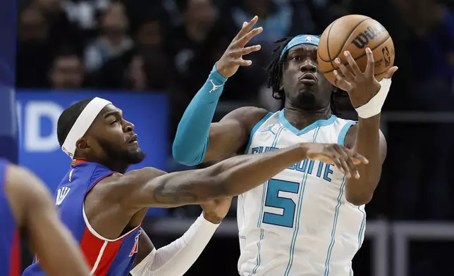 Detroit Pistons forward Paul Reed, left, tries to steal the ball from Charlotte Hornets center Mark Williams (5) during the first half of an NBA basketball game Friday, Jan. 3, 2025, in Detroit. (AP Photo/Duane Burleson)