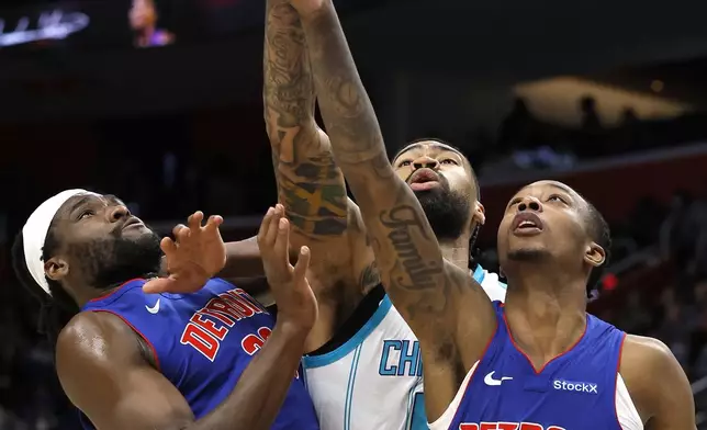 Detroit Pistons center Isaiah Stewart, left, and forward Ronald Holland II (00) crowd Charlotte Hornets center Nick Richards, center, while going for a rebound during the first half of an NBA basketball game Friday, Jan. 3, 2025, in Detroit. (AP Photo/Duane Burleson)