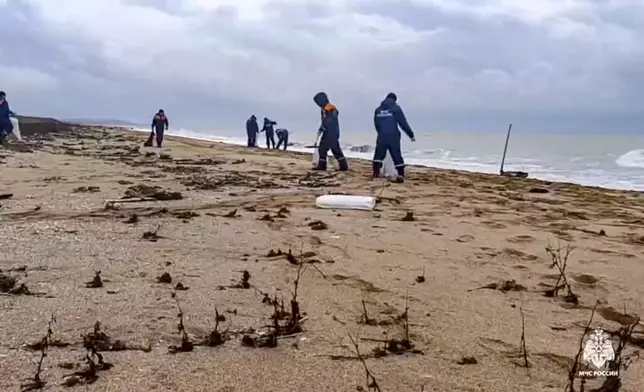 In this photo taken from video released by Russian Emergency Ministry Press Service on Saturday, Jan. 4, 2025, rescuers work to clean up tons of fuel oil that spilled out of two storm-stricken tankers more than two weeks ago in the Kerch Strait, in Russia's southern Krasnodar region. (Russian Emergency Ministry Press Service via AP)